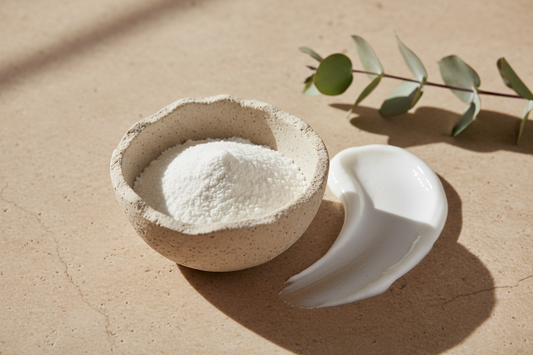 Zinc oxide mineral powder in a ceramic bowl beside a swipe of sunscreen cream with eucalyptus